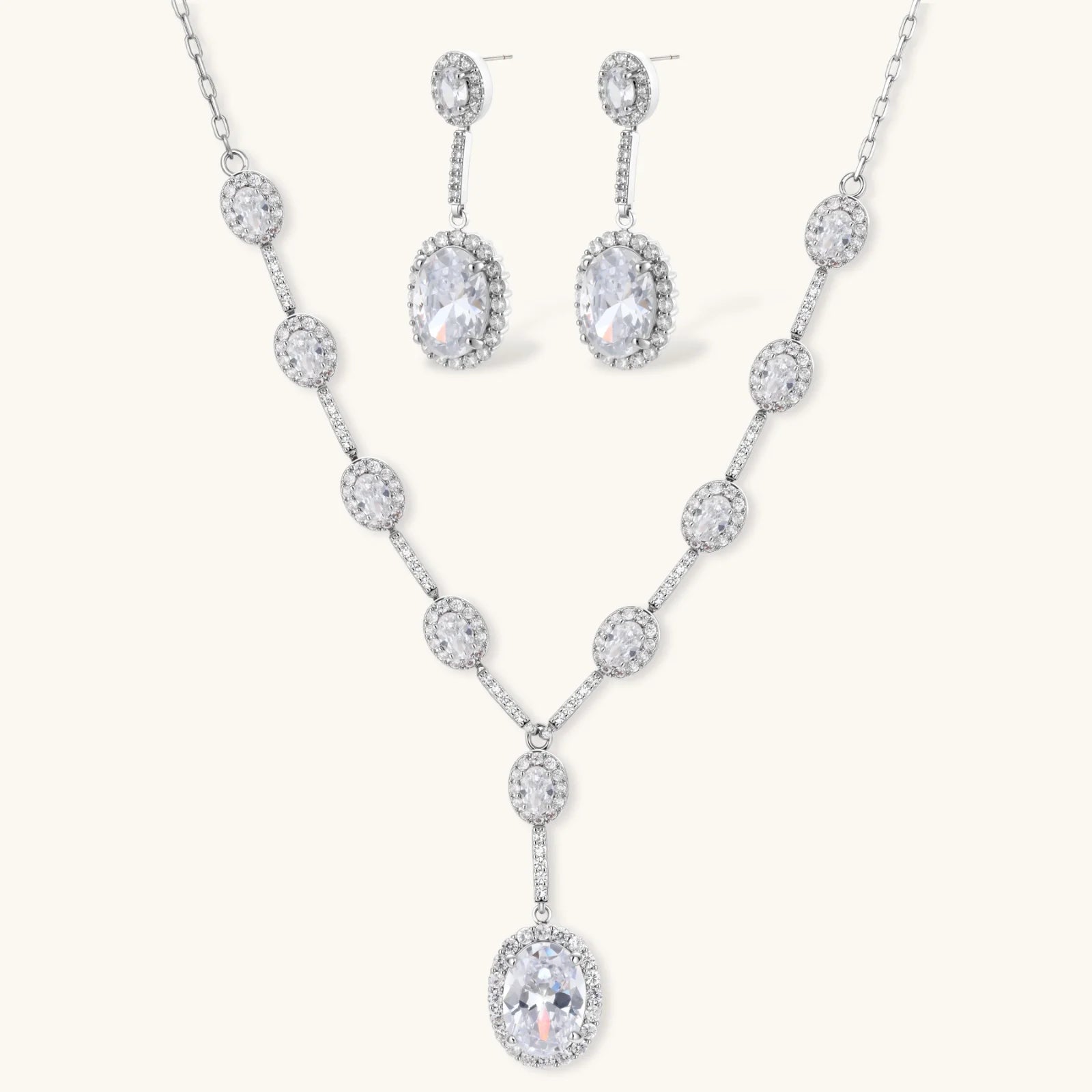 Elegant white gold plated jewelry set with oval cubic zirconia stones in halo settings, featuring Y-necklace and drop earrings.