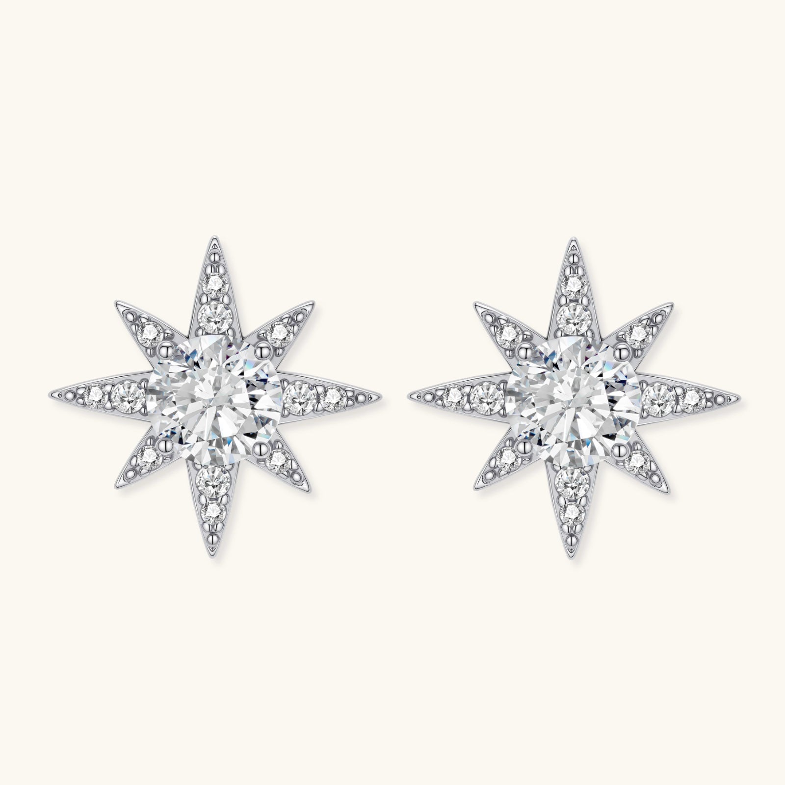 Sterling silver star-shaped stud earrings with brilliant moissanite center stones and pavé details on neutral background.